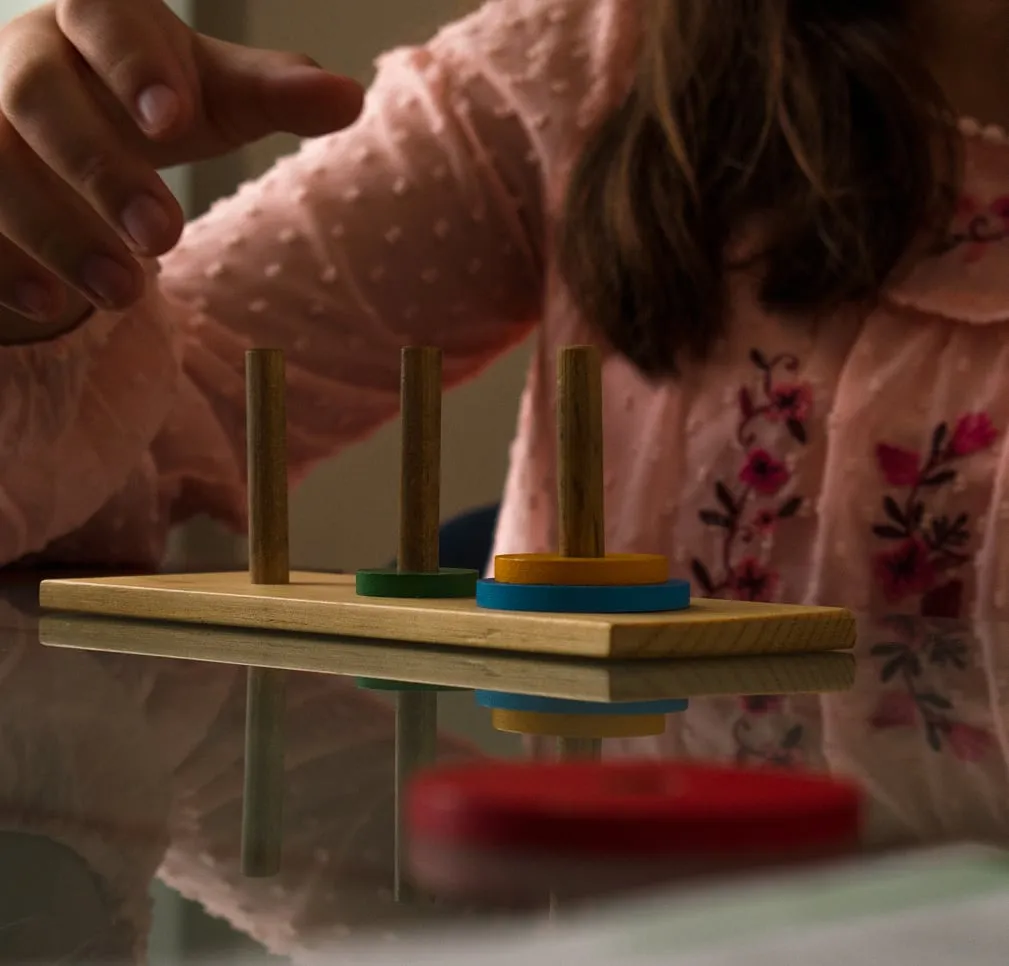 Niña resolviendo un ejercicio con piezas de madera